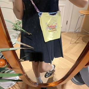 Mini yellow embroidered crossbody bag with carousel motif shown worn by a model