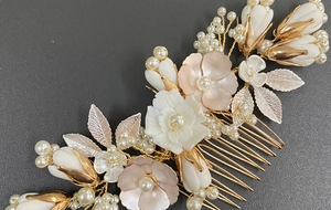 Detail of bridal hair comb with ceramic flowers and pearls on golden metal base