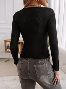 Vista dettagliata della trama a maglia e del design aperto sul retro del cardigan nero