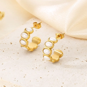 Close-up of 18k gold-plated stainless steel C-shaped earrings with white mother-of-pearl