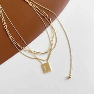 Vintage gold triple-layered necklace featuring letter L pendant and adjustable chains