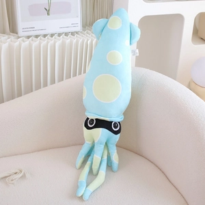 Close-up of a blue plush squid toy with green dots resting on a soft fabric sofa
