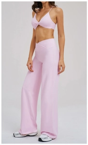 Detail of light pink yoga set featuring V-neck twist top and cross waist wide leg pants