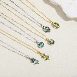 Detailed flat lay of flower and oval abalone shell necklaces in gold and silver finish