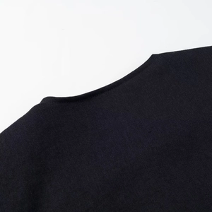 Macro view of precise stitching and high-density twill fabric on a black short trench jacket