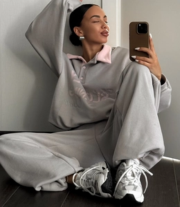 Détail du sweat polo gris avec col rose et broderie Sloane lors d'un selfie miroir