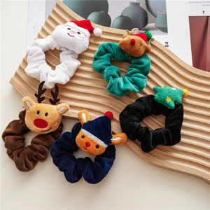 Set of 5 festive plush Christmas scrunchies with Santa and reindeer designs on wood tray