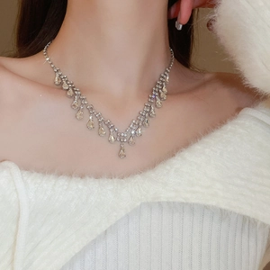 Close-up of layered silver teardrop fringe necklace with sparkling rhinestones on neck