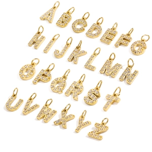 Macro shot of 26 golden alphabet pendants with clear cubic zirconia in pavé setting