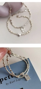 Macro detail of silver S925 heart and square charm bracelet with engraved text