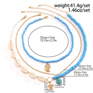 Detailed view of bohemian multilayer necklace with sea turtle and shell charms