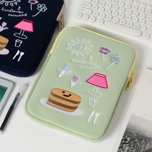 Detail of embroidered laptop sleeves with colorful sunflower and pancake patterns