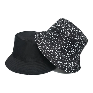 Women's reversible sun hat in solid black and white polka dot pattern on canvas