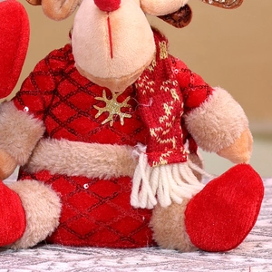 Close-up of reindeer plush toy in red sequin sweater with a golden snowflake detail