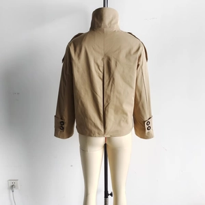 Rear view of khaki short trench coat featuring back pleat detail and adjustable cuff straps