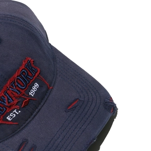 Detail of navy blue distressed baseball cap with red New York embroidery and stitching