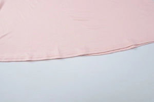 Detail showing high-quality double-needle hem stitching on a pink bodycon dress fabric
