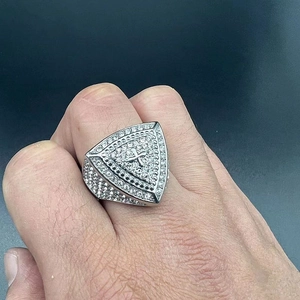 Macro detail of silver men's ring with cross relief and pavé set sparkling crystals