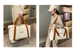 Detail of a large capacity travel tote bag with brown straps and HAYUN logo on white canvas