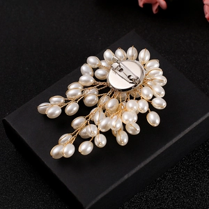 Handcrafted pearl brooch with gold wire wrap on black gift box, back pin view