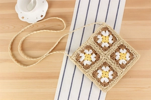Détail d'un sac au crochet fait main avec motifs de marguerites et bandoulière tissée