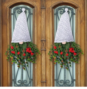 Detail view of gnome Christmas wreath with pine needles, berries and pine cones on wood door