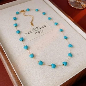 Detail of bohemian heart turquoise necklace with gold chain and lobster clasp closure
