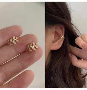Macro detail of gold leaf ear cuff featuring sparkling rhinestones and a model try-on look