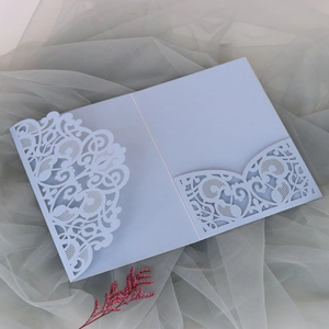 Detailed view of light blue laser-cut floral wedding invitation cover on grey tulle
