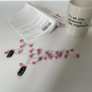 Dettaglio delle nappe di fiori in rilievo rosa su fermagli per capelli in metallo
