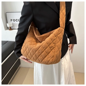 Brown quilted corduroy tote bag showing large capacity and stylish texture on a shoulder
