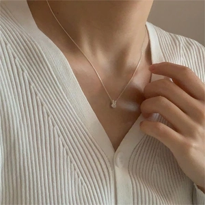 Close-up of minimalist 925 sterling silver rabbit pendant necklace on a woman's neck