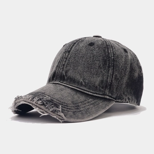 Detailed view of washed denim baseball cap featuring vintage distressed torn brim edges