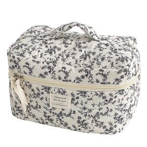 Quilted floral toiletry bag with black floral pattern and ribbon zipper handle