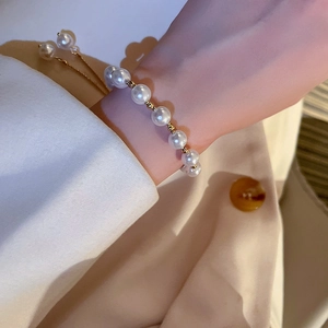 Close-up of elegant pearl bracelet with adjustable gold chain on a woman's wrist