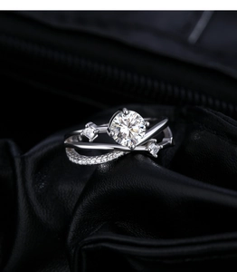 Macro shot of silver ring featuring elegant crisscross bands and a brilliant moissanite stone