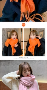 Detailed view of soft orange and pink cashmere-like scarves with fringe and thick texture