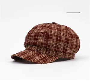 Detail of orange plaid octagonal cap with top button and textured woven fabric