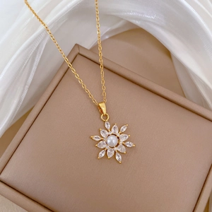 Elegant gold necklace featuring a flower pendant with center pearl and cubic zirconia
