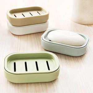 Macro view of double-layer drainage soap dishes in various pastel colors on wooden surface