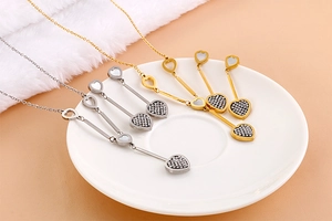 Detail of heart necklaces and earrings set with pavé crystals and mother of pearl