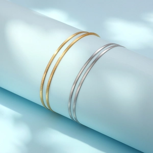Double-layered gold and silver snake bone chain bracelets for women on a blue prop