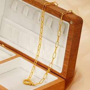 Detail of 18k gold paperclip necklace with toggle clasp in a wooden jewelry box
