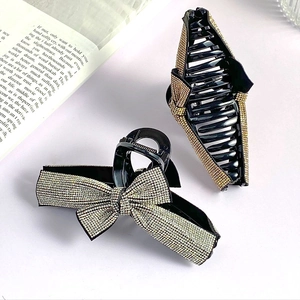 Close-up of elegant rhinestone bow hair claws and geometric clips with gold crystals
