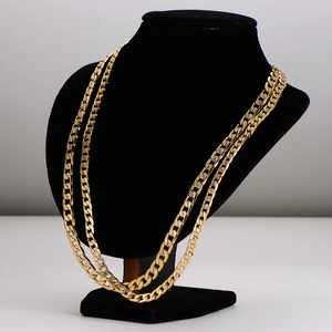 Polished gold double Cuban link chain necklace displayed on a professional jewelry bust