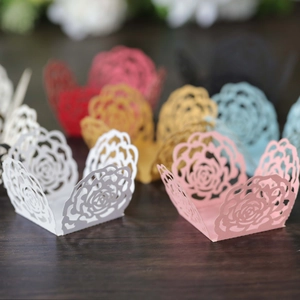 Detailed laser-cut rose hollow paper gift boxes in multiple colors on wooden background