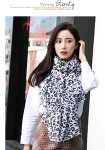 Detail of a lightweight black and white leopard print scarf worn by a model in the city