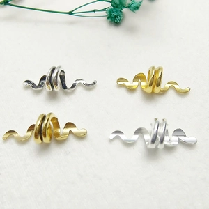 Vintage snake dreadlock hair ring in gold and silver finish on white felt background