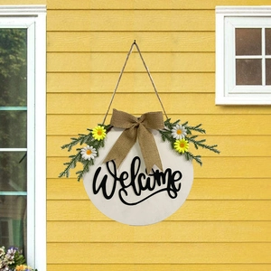 Detail of wooden welcome sign with burlap bow, white daisies and greenery for Easter