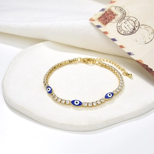 Golden tennis bracelet with sparkling zircons and blue enamel Evil Eye charms